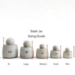 JONES + CO Stash Jars in matte charcoal stoneware with glossy black interior and chunky knob. Sizing guide shows XL, Large, Medium, Small, and Mini jars.