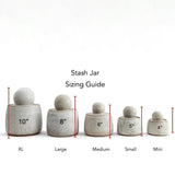 JONES + CO Stash Jars in matte charcoal stoneware with glossy black interior and chunky knob. Sizing guide shows XL, Large, Medium, Small, and Mini jars.