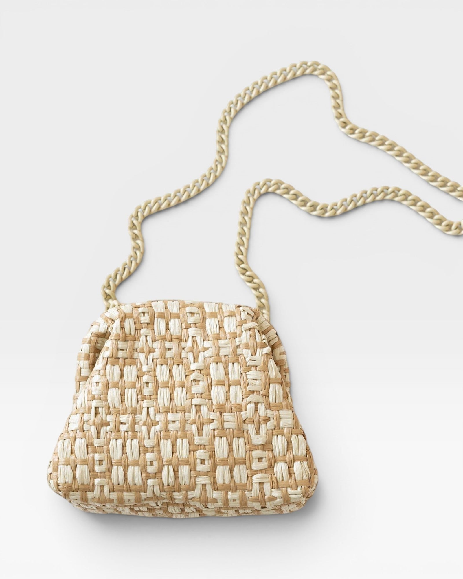 JONES + CO natural woven raffia Stella clutch with a gold chain strap.