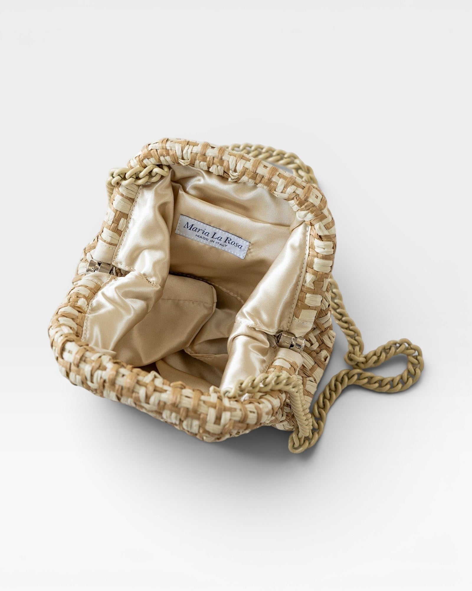 JONES + CO Stella Clutch in natural woven raffia with a satin lining and a tone-on-tone chain strap.