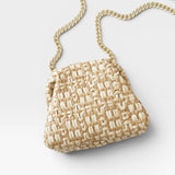 JONES + CO Stella Clutch in natural woven straw with a gold chain strap.