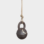 JONES + CO round extra dark stoneware jingle bell with hand-painted yellow crescent moon on a hemp rope hanger.