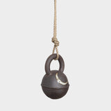 JONES + CO round extra dark stoneware jingle bell with hand-painted yellow crescent moon on a hemp rope hanger.