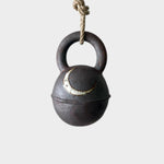 JONES + CO round extra dark stoneware jingle bell featuring a hand-painted crescent moon, hanging on a hemp rope.