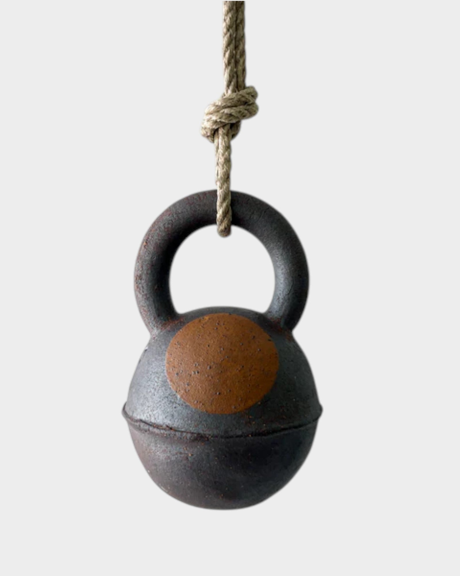 JONES + CO extra dark stoneware jingle bell with a hand-painted yellow crescent moon design on hemp rope.