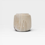 JONES + CO handcrafted beige stoneware pot with white glaze drips, smooth cylindrical shape, modern artisan style.