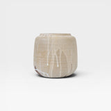 JONES + CO handcrafted beige stoneware pot with white glaze drips, smooth cylindrical shape, modern artisan style.