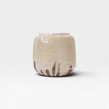 JONES + CO handcrafted stoneware pot with smooth cylindrical shape, beige finish, and natural white glaze drips.
