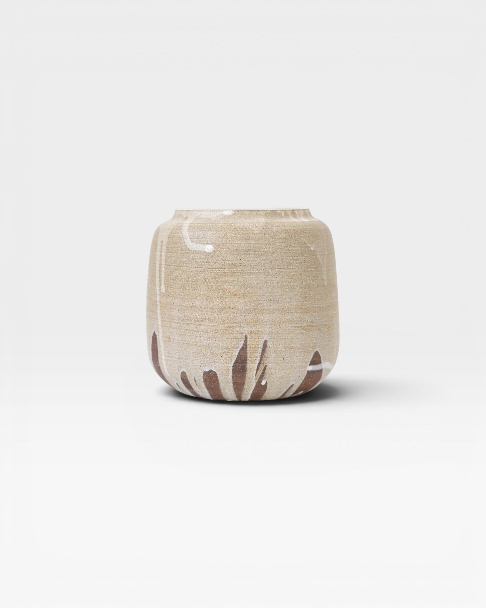JONES + CO handcrafted stoneware pot with smooth cylindrical shape, beige finish, and natural white glaze drips.