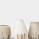 JONES + CO handcrafted beige stoneware pot with white glaze drips and smooth cylindrical shape.
