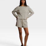 Model wearing JONES + CO natural and chocolate striped loop terry sweatshorts with a matching long sleeve top.