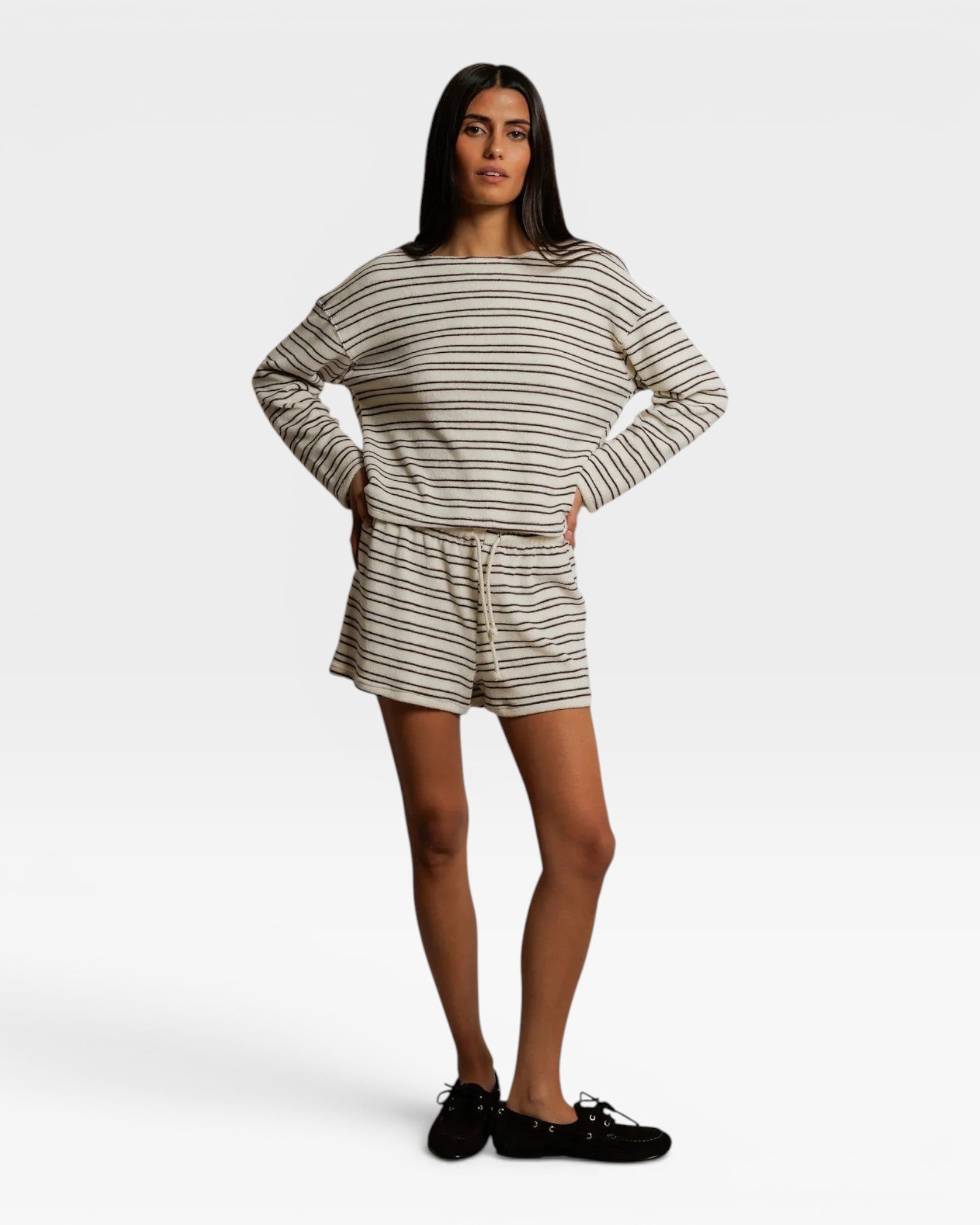 Model wearing JONES + CO natural and chocolate striped loop terry sweatshorts with a matching long sleeve top.