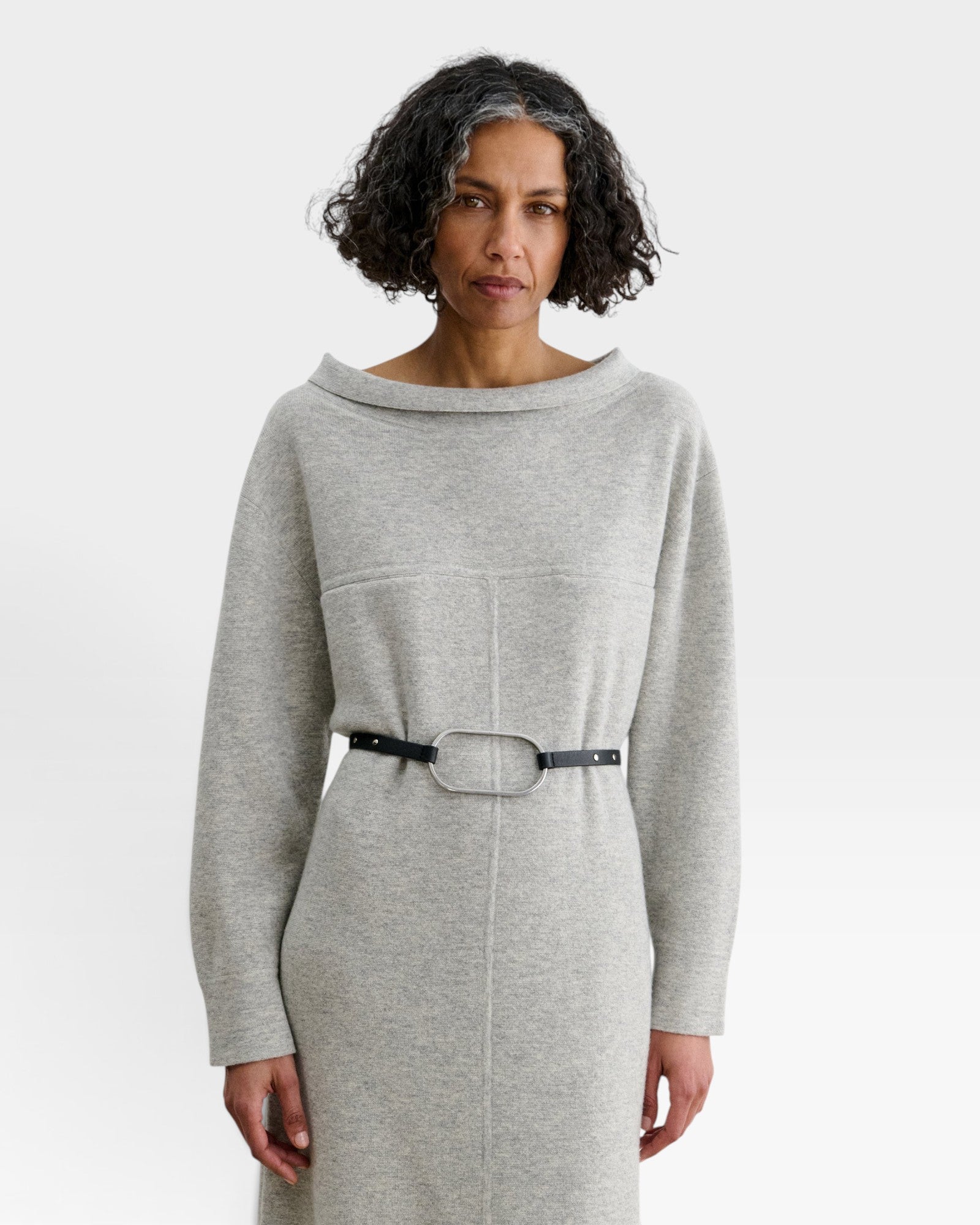 JONES + CO Studded Cole Belt in black leather with an oversized oval buckle worn over a grey knit dress
