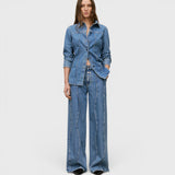 JONES + CO Tali-X mid blue denim jeans with high waist, wide leg, and signature curved seaming on a model