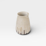 JONES + CO tall stoneware vase with a speckled cream glaze and a drip effect in brown at the base.