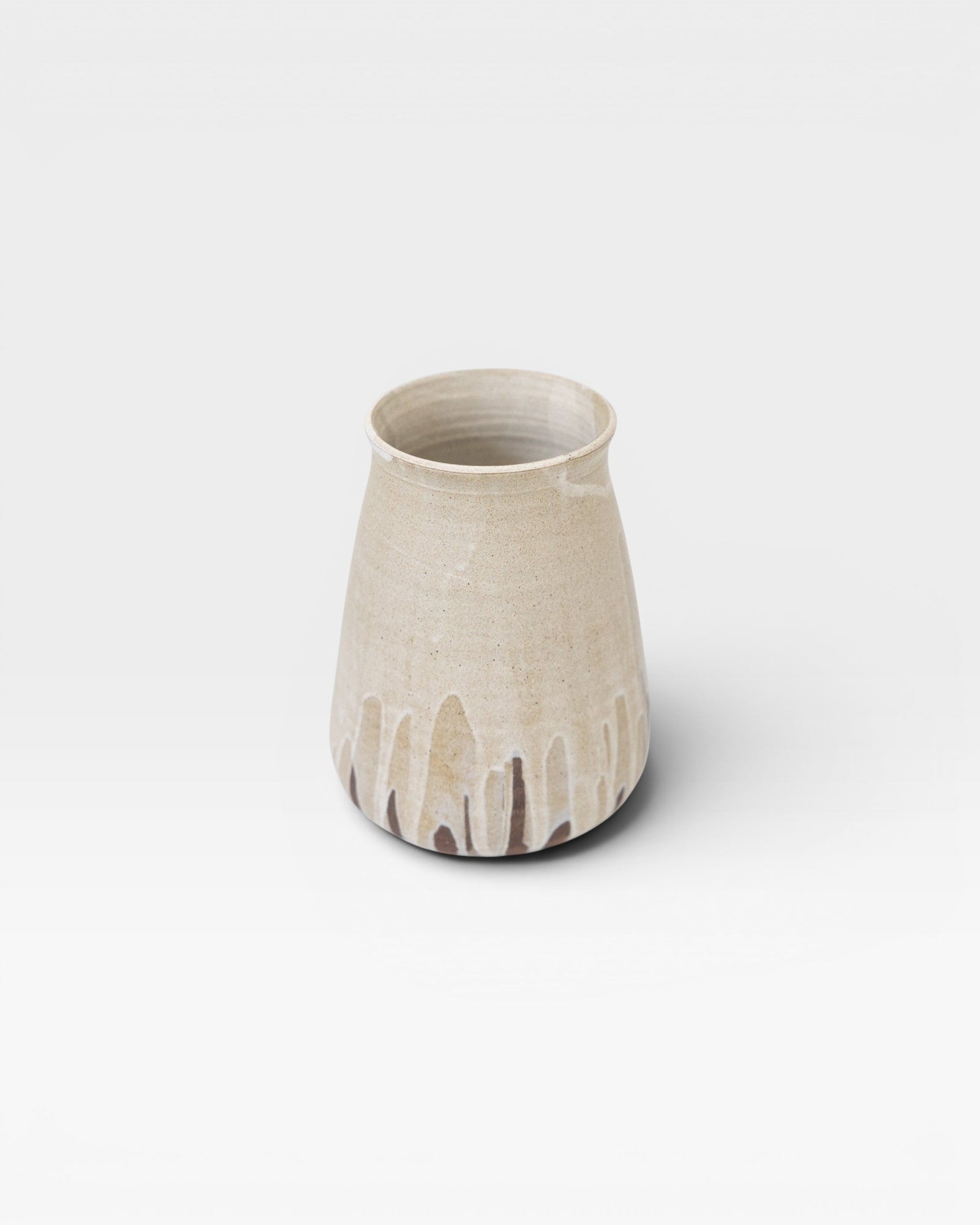 JONES + CO tall stoneware vase with a speckled cream glaze and a drip effect in brown at the base.