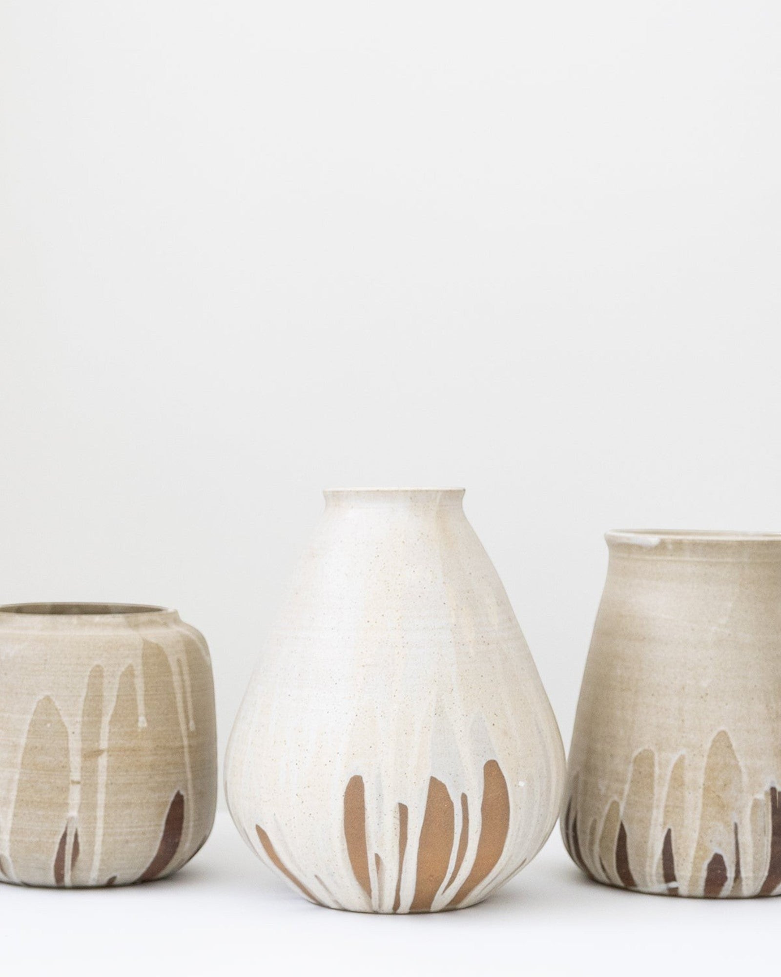 JONES + CO tall stoneware vase with a cream speckled glaze and brown drip detail. Handthrown ceramic.