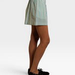 JONES + CO Julie poplin shorts in teal blue and white sugar stripes with a smocked elastic waistband, side view.