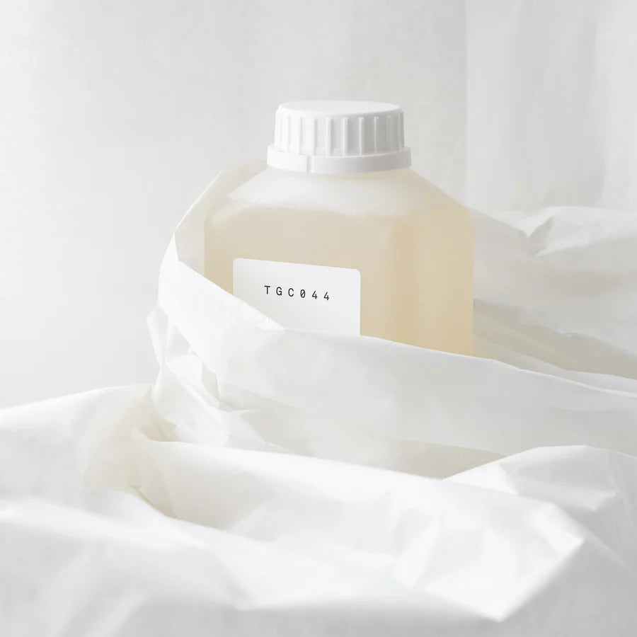 White bottle with a label on a white fabric background