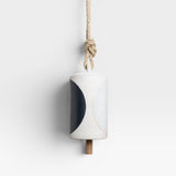 JONES + CO Thrown Bell - Domino Indigo ceramic bell with indigo and white half-moon design, hanging from rope.