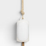 JONES + CO Thrown Bell - Domino Indigo, white ceramic bell with oval inlay, hanging from jute rope.
