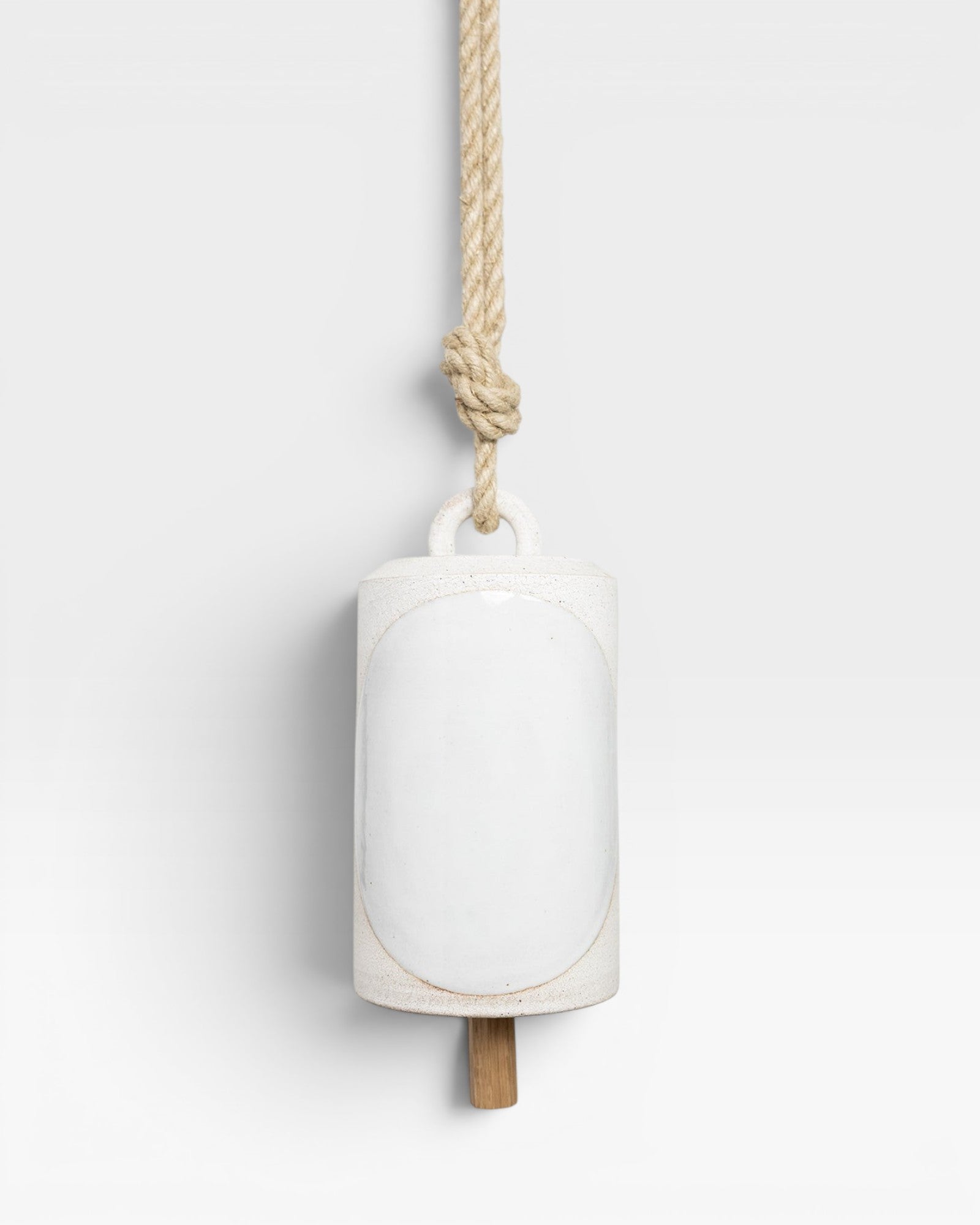 JONES + CO Thrown Bell - Domino Indigo, white ceramic bell with oval inlay, hanging from jute rope.
