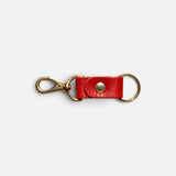 JONES + CO tomato red leather keychain with gold-tone metal hardware and a secure snap button closure.