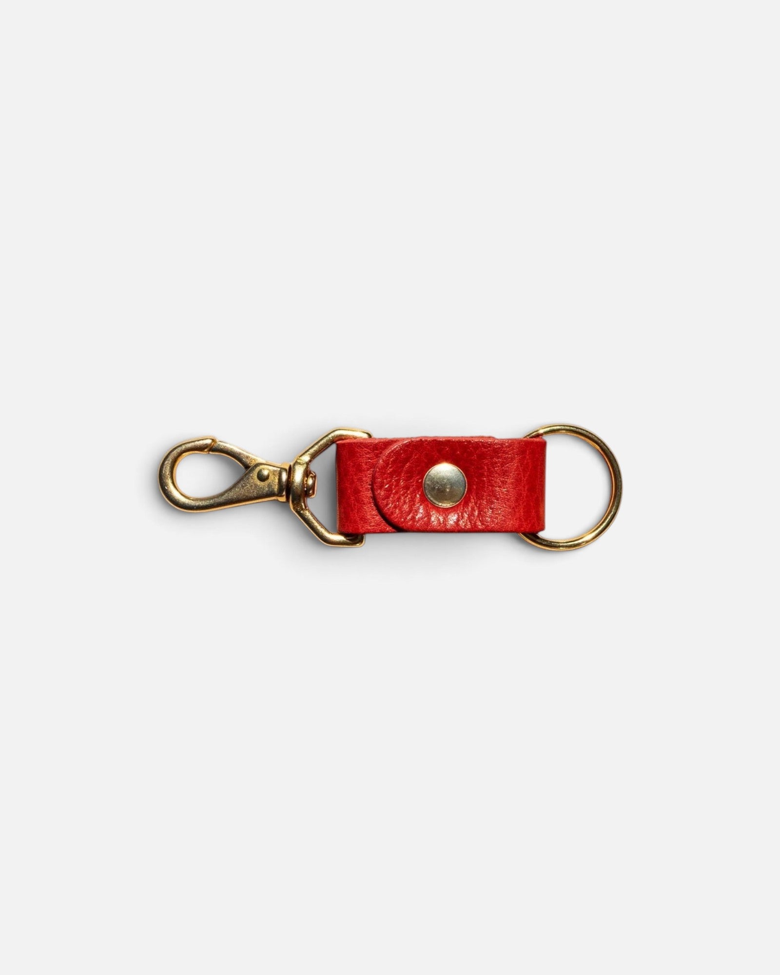 JONES + CO tomato red leather keychain with gold-tone metal hardware and a secure snap button closure.