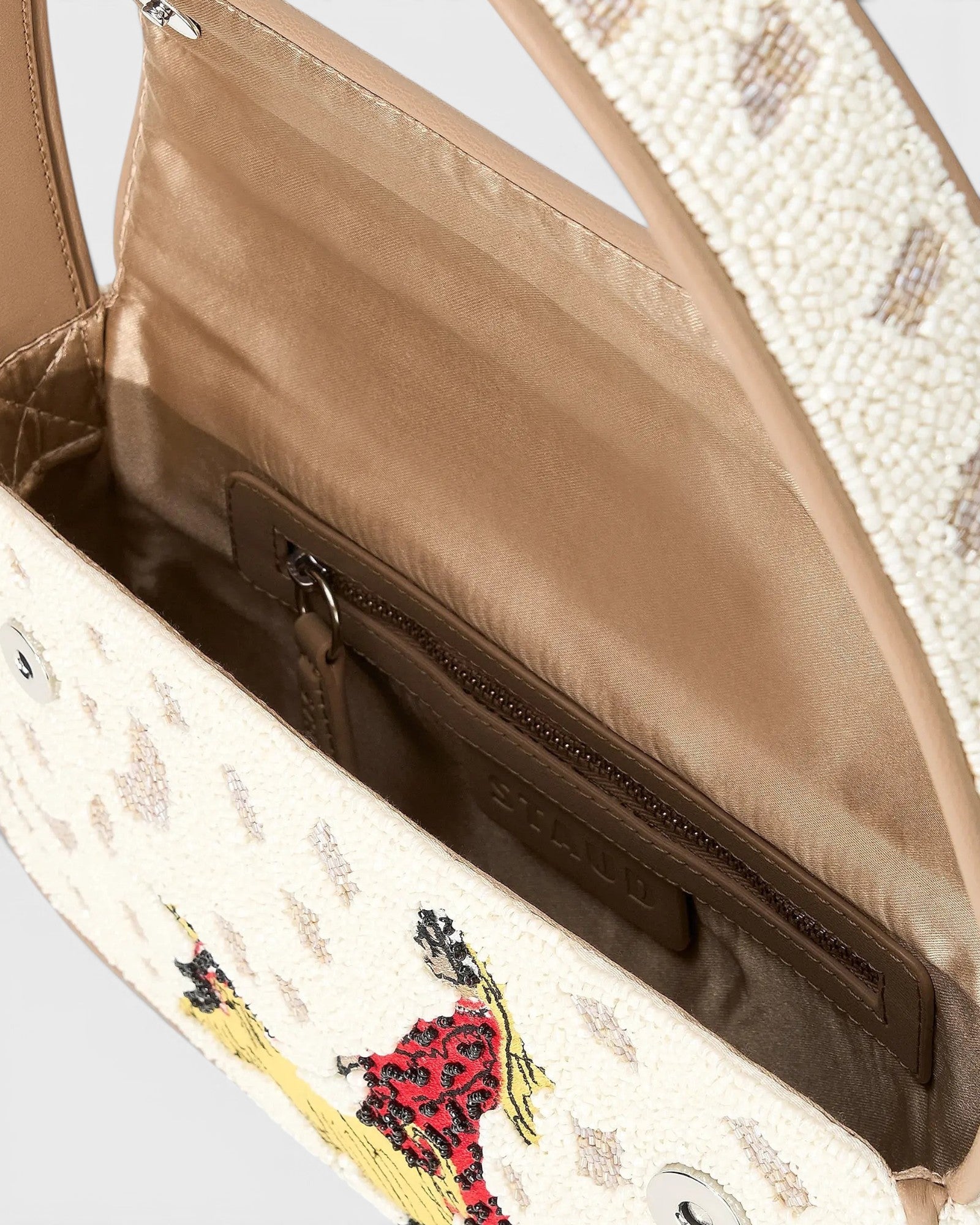 JONES + CO Tommy hand-beaded shoulder bag with dog walk pattern, vegan leather piping, and interior zip pocket.