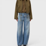 JONES + CO Tori-X barrel jeans in mid blue denim with signature X-pockets and offset side seams on a model.
