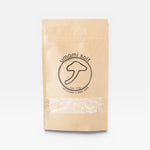 JONES + CO Umami Salt in a brown paper pouch with a shiitake mushroom logo and clear window for viewing the salt.