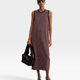 JONES + CO Valley midi dress in russet stretchy check fabric with contrast black binding, worn by a model.