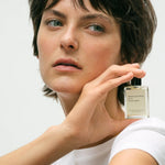 JONES + CO No.15 Vanille Infinie perfume oil bottle held by a woman with short brown hair and green eyes.