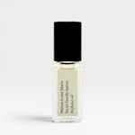 JONES + CO No.15 Vanille Infinie travel size perfume oil in a clear glass rollerball bottle with a black cap.