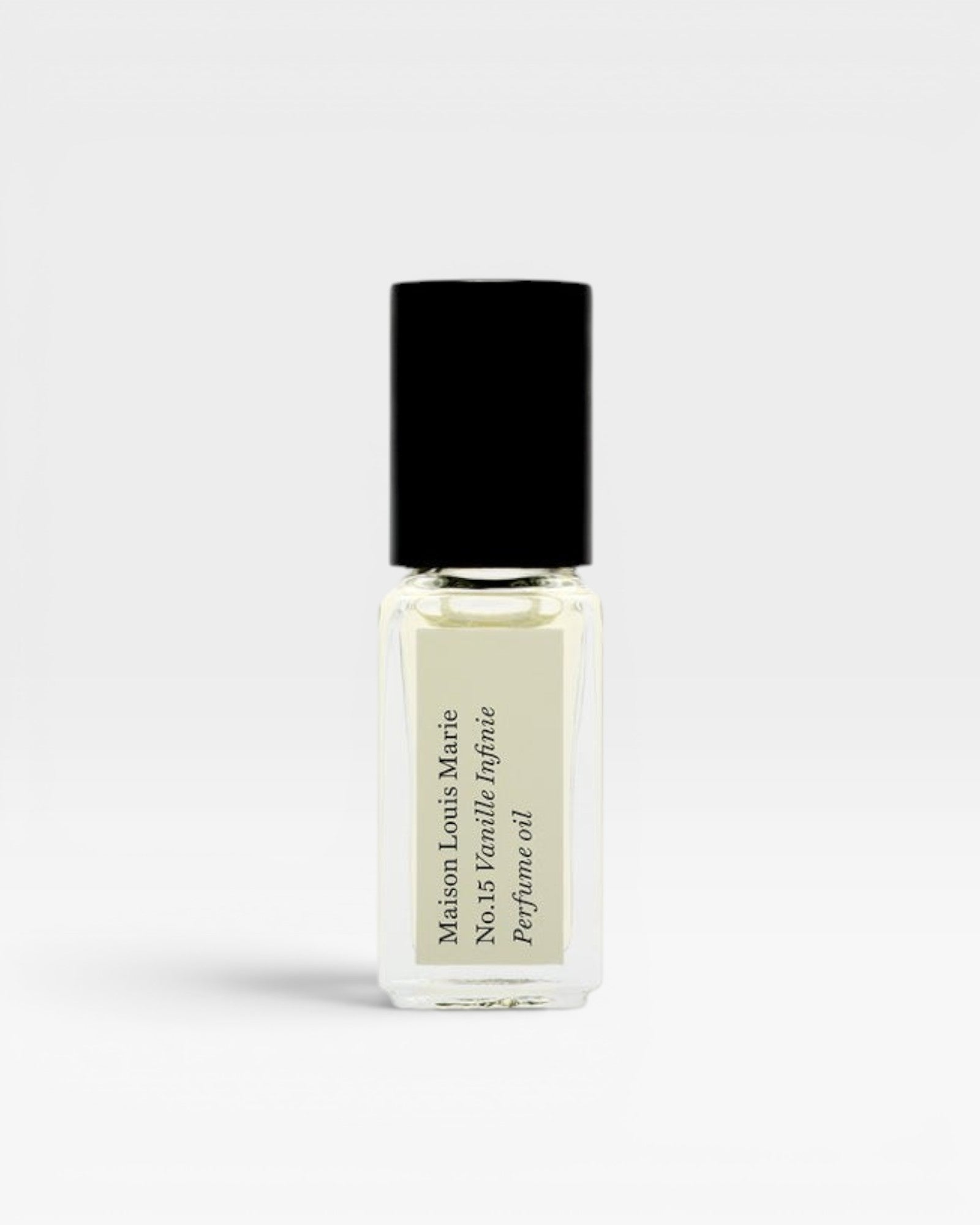 JONES + CO No.15 Vanille Infinie travel size perfume oil in a clear glass rollerball bottle with a black cap.