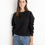 Woman wearing a JONES + CO vintage black textured crewneck sweatshirt with ribbed cuffs and hem