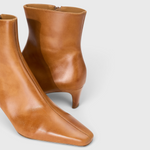 JONES + CO Wally ankle boot in distressed cashew leather with a pointed rectangular toe and slim blade heel.
