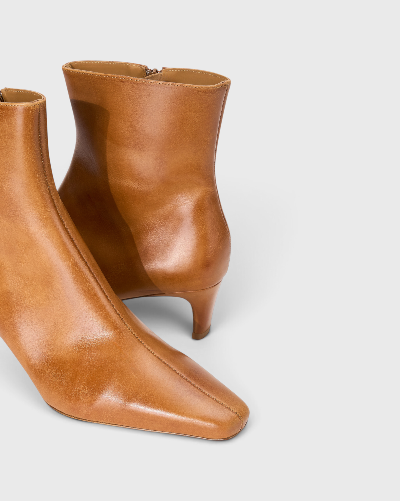 JONES + CO Wally ankle boot in distressed cashew leather with a pointed rectangular toe and slim blade heel.