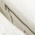 JONES + CO white beaded shoulder bag with 3D floral embellishments and vegan leather trim. Features inner zip pocket.