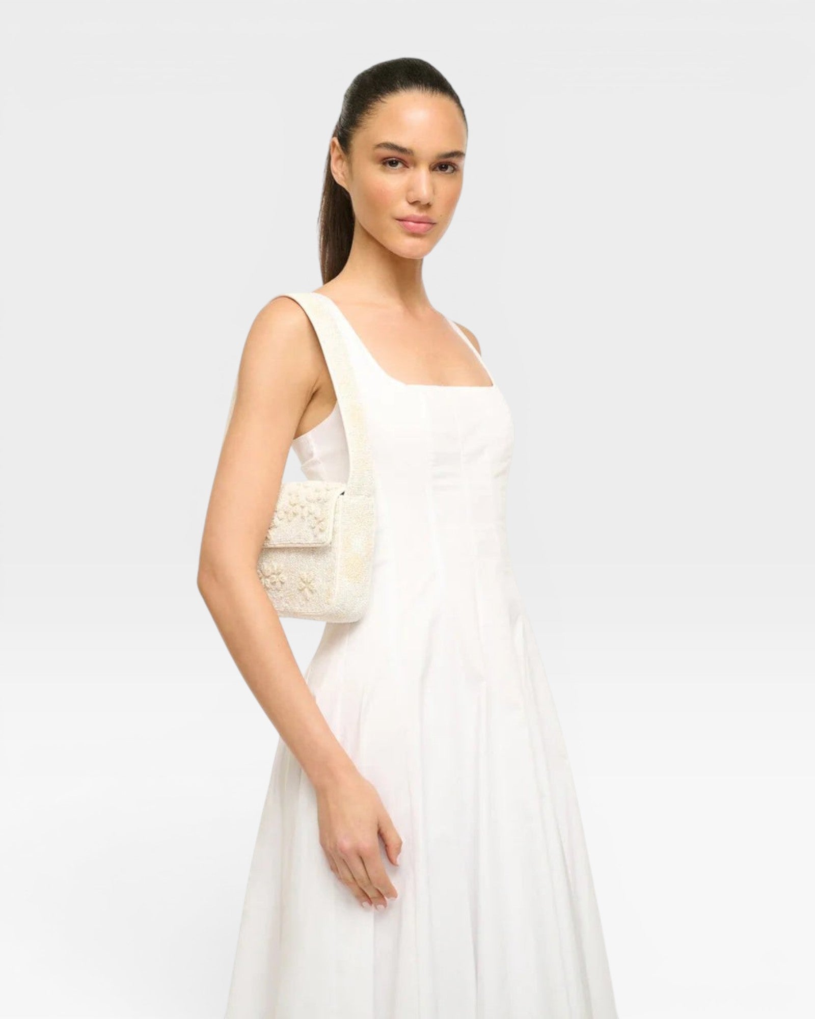 JONES + CO white beaded shoulder bag with 3D floral embellishments and vegan leather piping.