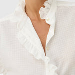 JONES + CO white organic cotton voile blouse with tone-on-tone check, ruffles, and mother-of-pearl buttons.