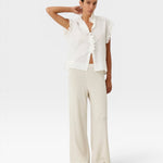 JONES + CO white organic cotton voile sleeveless blouse with tone-on-tone check, ruffles, and mother-of-pearl buttons.
