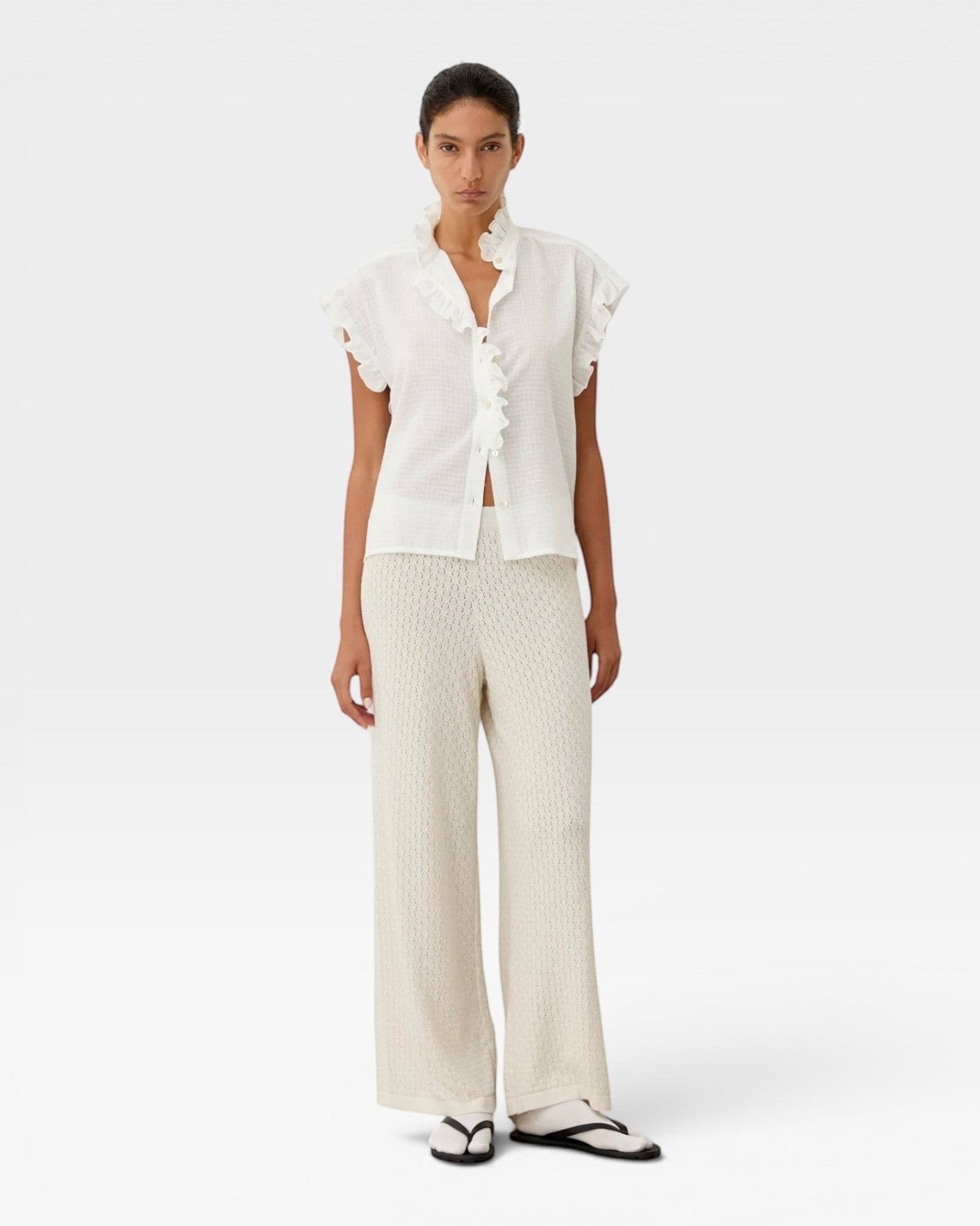 JONES + CO white organic cotton voile sleeveless blouse with tone-on-tone check, ruffles, and mother-of-pearl buttons.