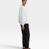 JONES + CO white organic cotton voile blouse with gathered cuffs and deep V-neckline, featuring a subtle checkered pattern.