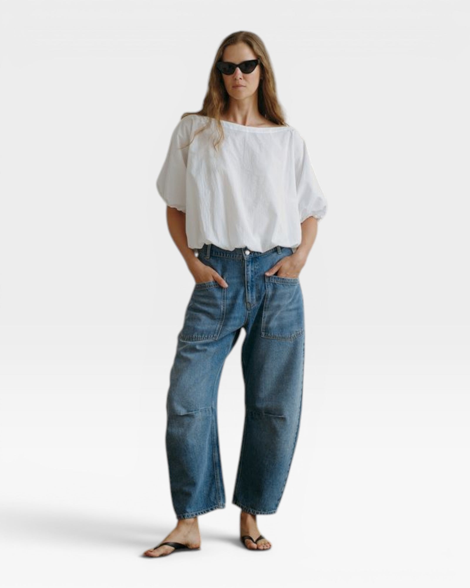 JONES + CO white cotton Coco shirt with boat neckline and dolman sleeves, gathered hem. Model wears sunglasses.