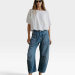 JONES + CO white Coco shirt with boat neckline and dolman sleeves, paired with blue jeans.