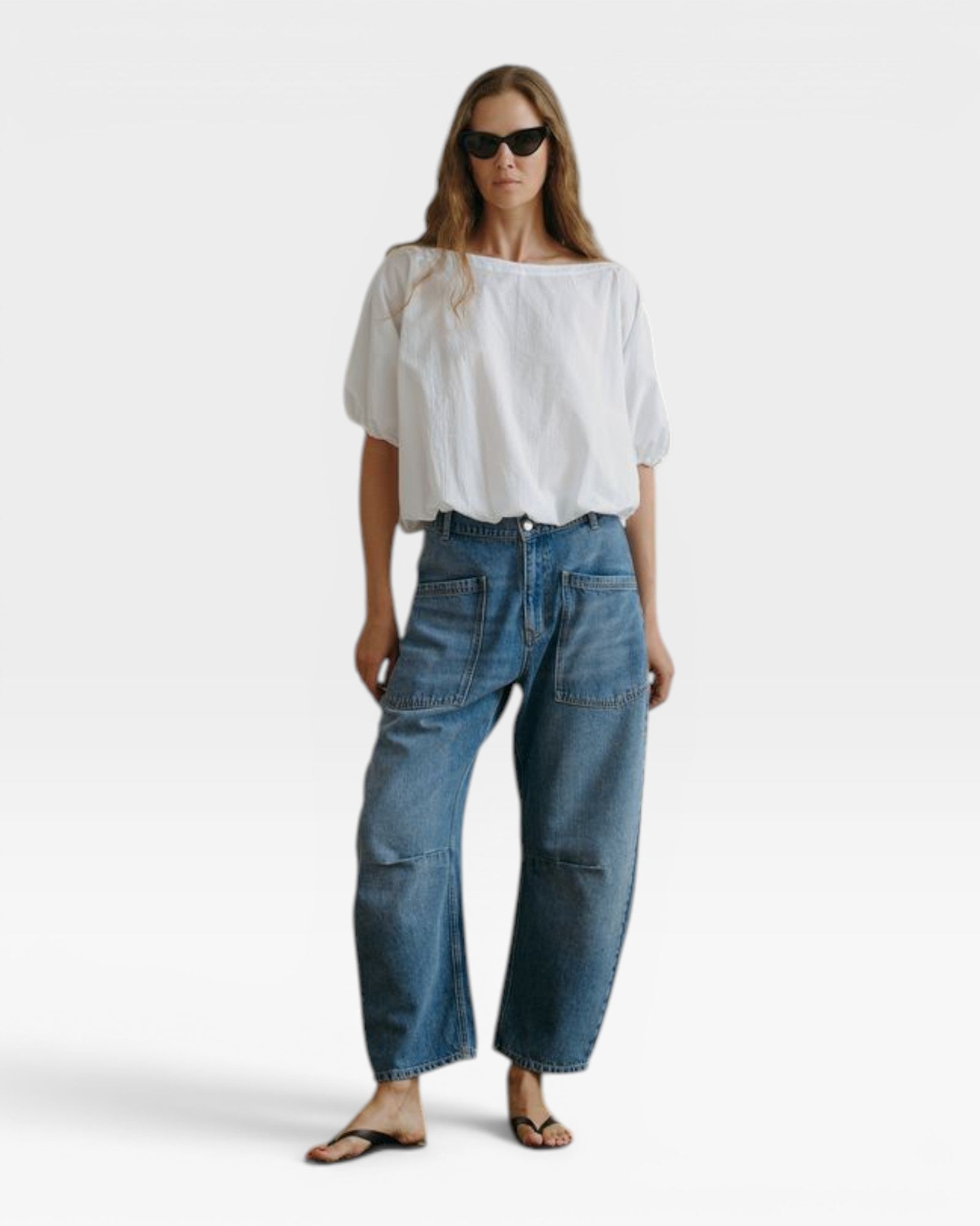 JONES + CO white Coco shirt with boat neckline and dolman sleeves, paired with blue jeans.