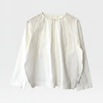 JONES + CO white cotton Julienne long sleeve top with round neckline, keyhole closure, pleating, and raglan sleeves.