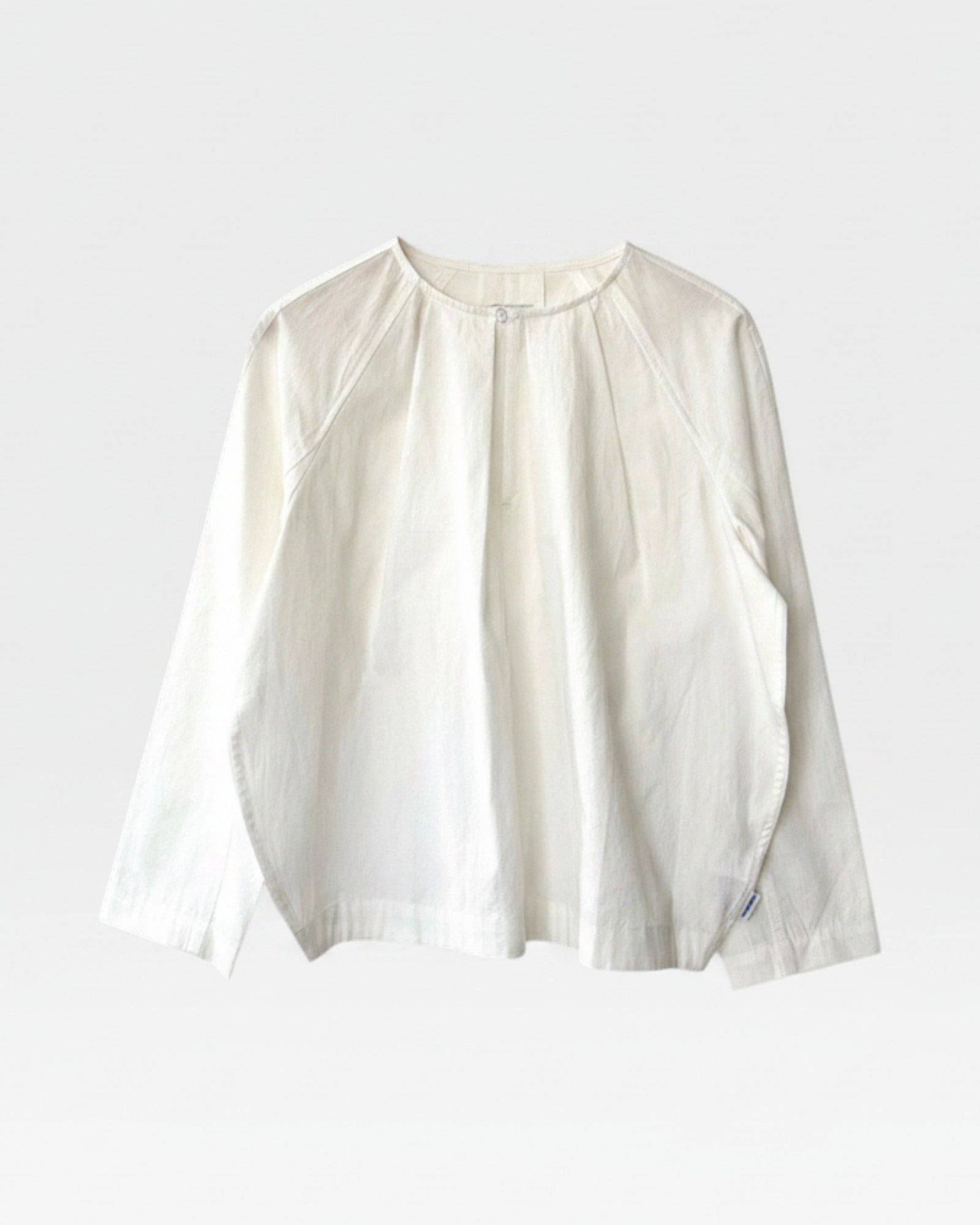 JONES + CO white cotton Julienne long sleeve top with round neckline, keyhole closure, pleating, and raglan sleeves.