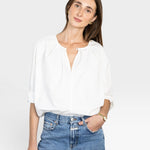 JONES + CO white cotton Julienne long sleeve top with keyhole neckline and pleating. Model wears jeans.